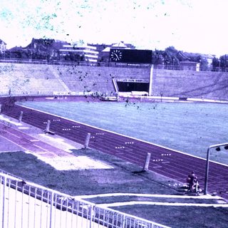 An outdoor track and field stadium with seating.