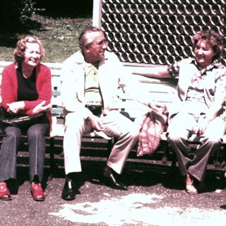 Group of people sitting on a park bench.