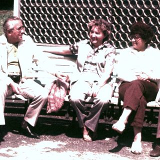 Group of people sitting on a park bench.