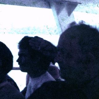 People seated indoors, possibly on a boat or public transport.