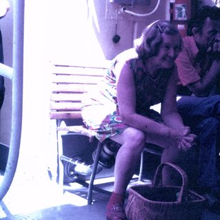 Woman sits next to a man, basket nearby.