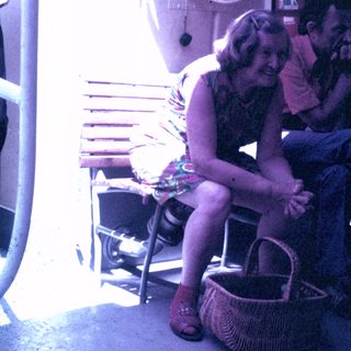 Woman sits next to a man, basket nearby.