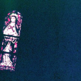 Stained glass window depicts a figure in robes.