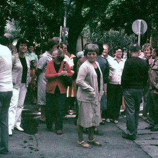 Group of people standing and talking on a street.