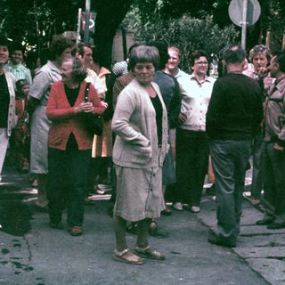 Group of people standing and talking on a street.