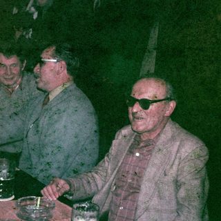 Men seated at a table, appearing to socialize.