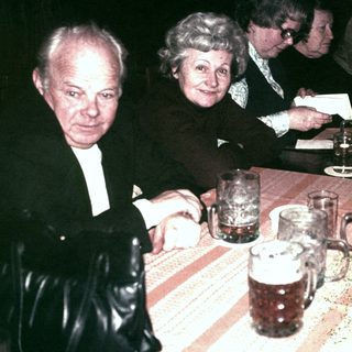 Group of people seated at a table with beer mugs.