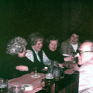 Group of people seated at a table, seemingly socializing.