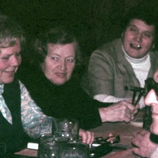 Group of people seated at a table, seemingly socializing.
