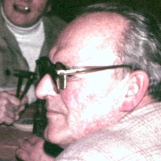 Group of people seated at a table, seemingly socializing.