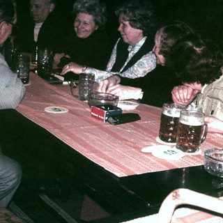 Group of people seated at a table, enjoying drinks.