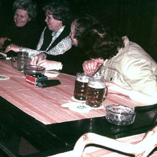 Group of people seated at a table, enjoying drinks.