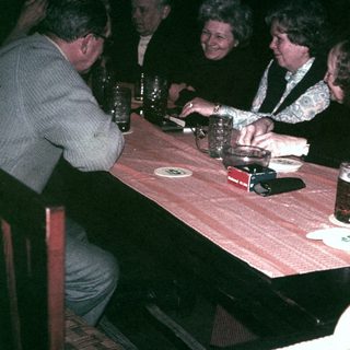 Group of people seated at a table, enjoying drinks.