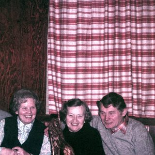 Four people are seated at a table, smiling.
