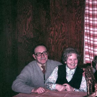 Four people are seated at a table, smiling.