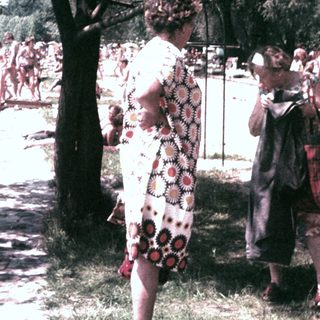 People relax and socialize near a beach on a sunny day.