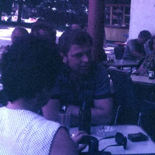 Group of men seated outdoors, possibly at a restaurant.