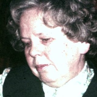 Two women seated at a table, appearing to be writing.