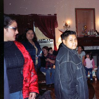 Group of people gathered in a room with a fireplace.