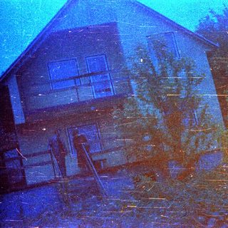 Here's a brief summary: Two-story house with visible windows and trees nearby.