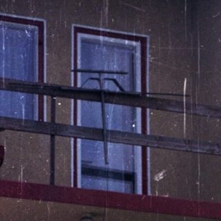 Couple stands on steps in front of an apartment building.