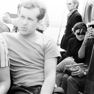 Men on a boat, some smoking, in black and white.