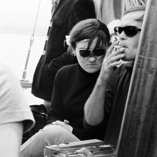 Men on a boat, some smoking, in black and white.