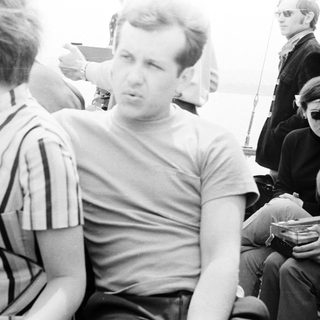Men on a boat, some smoking, in black and white.