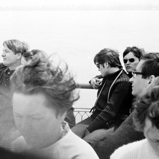 Men on a boat, looking out over water.