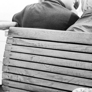 People sitting on a boat with a box in between.