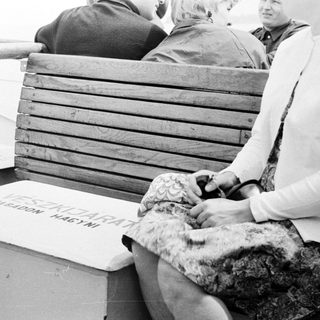 People sitting on a boat with a box in between.