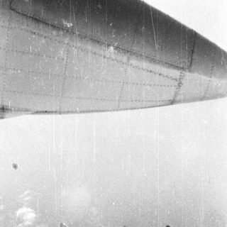 Close-up view of an airplane wing with visible scratches.