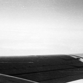 Black and white image of an airplane wing in flight.