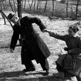 Man and woman appear to be struggling outdoors.