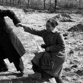 Man and woman appear to be struggling outdoors.