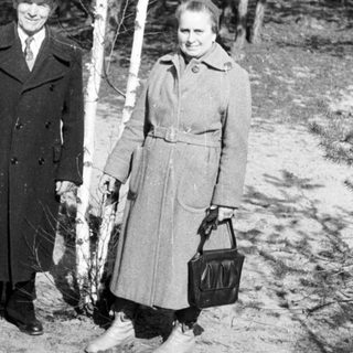 Black and white photo of a couple standing near birch trees.