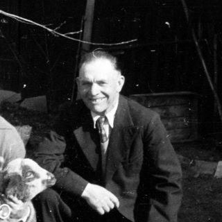 Black and white photo of a man, woman, and a lamb.