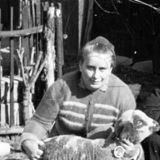 Black and white photo of a man, woman, and a lamb.