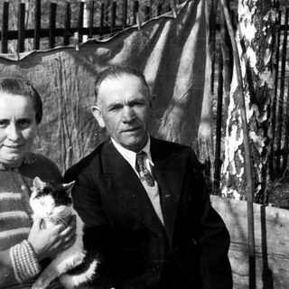 Black and white portrait of a couple holding a cat.