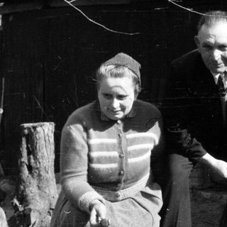 Black and white photo of a couple outside a building.