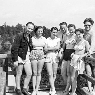 Group poses for a photo overlooking a forested hillside.
