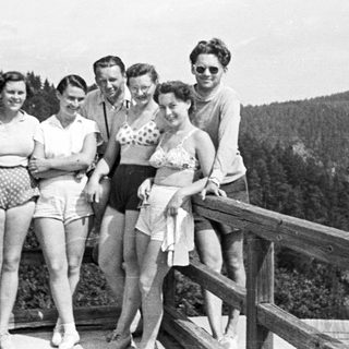 Group poses for a photo overlooking a forested hillside.