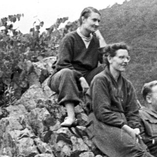 Group of people relaxing on a rocky hillside.