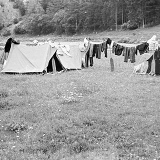 Black and white image of tents and drying laundry.