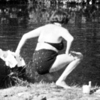People relaxing by a waterfall and swimming in a river.