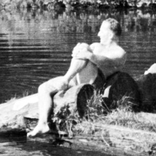 People relaxing by a waterfall and swimming in a river.