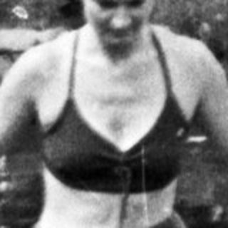 Woman in swimwear wading in a body of water.