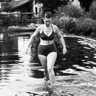 Woman in swimwear wading in a body of water.