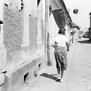 People walking down a narrow, old street.