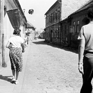 People walking down a narrow, old street.